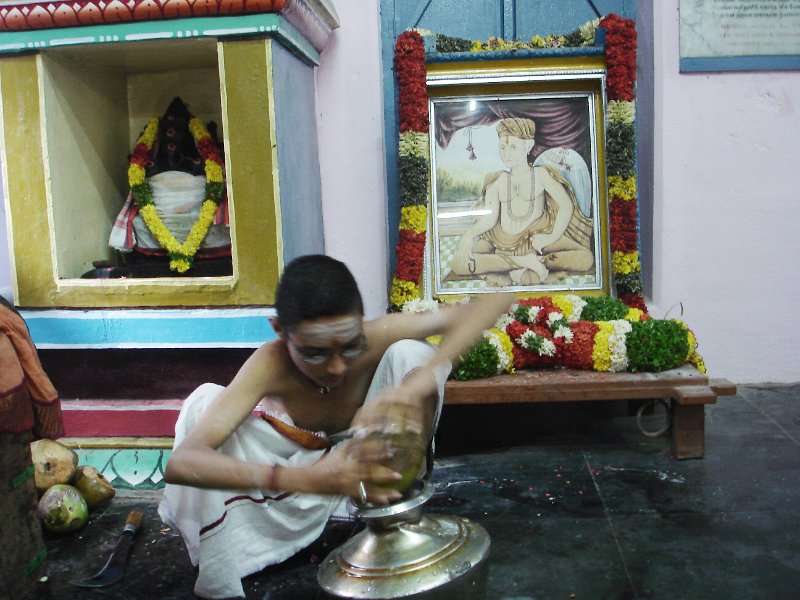 DSC03290.JPG - A boy collects tender cocnut water for the abishekam at the Thiagaraja shrine