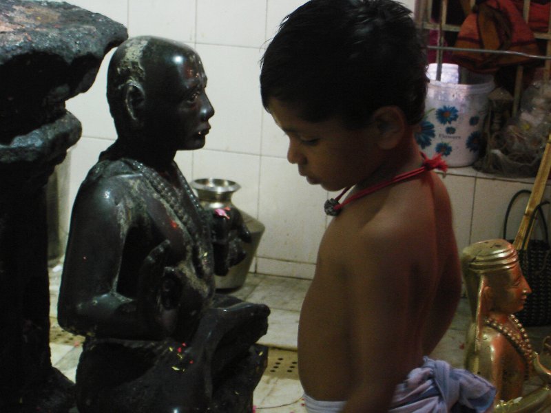 DSC03293.JPG - A boy stands in front of the image of Thiagaraja as priests prepare for abishekam